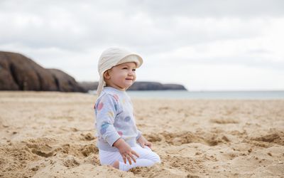婴儿在海滩上戴着帽子