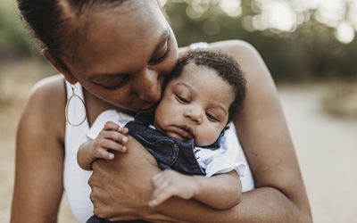 年轻的非洲裔美国母亲抱着一个婴儿