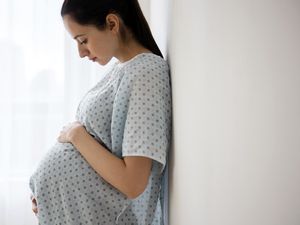 公关egnant Caucasian woman holding her belly in hospital