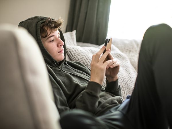 Teenage boy using smartphone at home