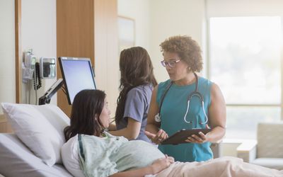 一个孕妇在医院的病床上和医生说话