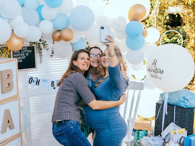 Female friends taking selfie with pregnant woman at a baby shower