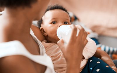 Shot of a mother feeding her adorable infant daughter at home