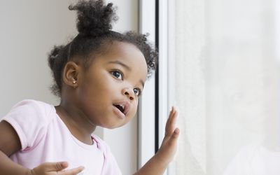 cute Black baby girl looking out of the window