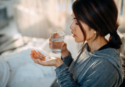 女人手里拿着药丸准备吃