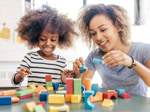 A mom and daughter playing with blocks