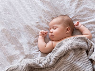 Peaceful baby lying on a bed and sleeping at home