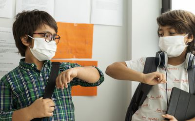 年幼的男孩戴着面具在学校里互相碰撞