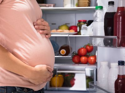Pregnant woman at refrigerator