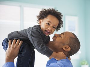 Dad lifting up his young son.