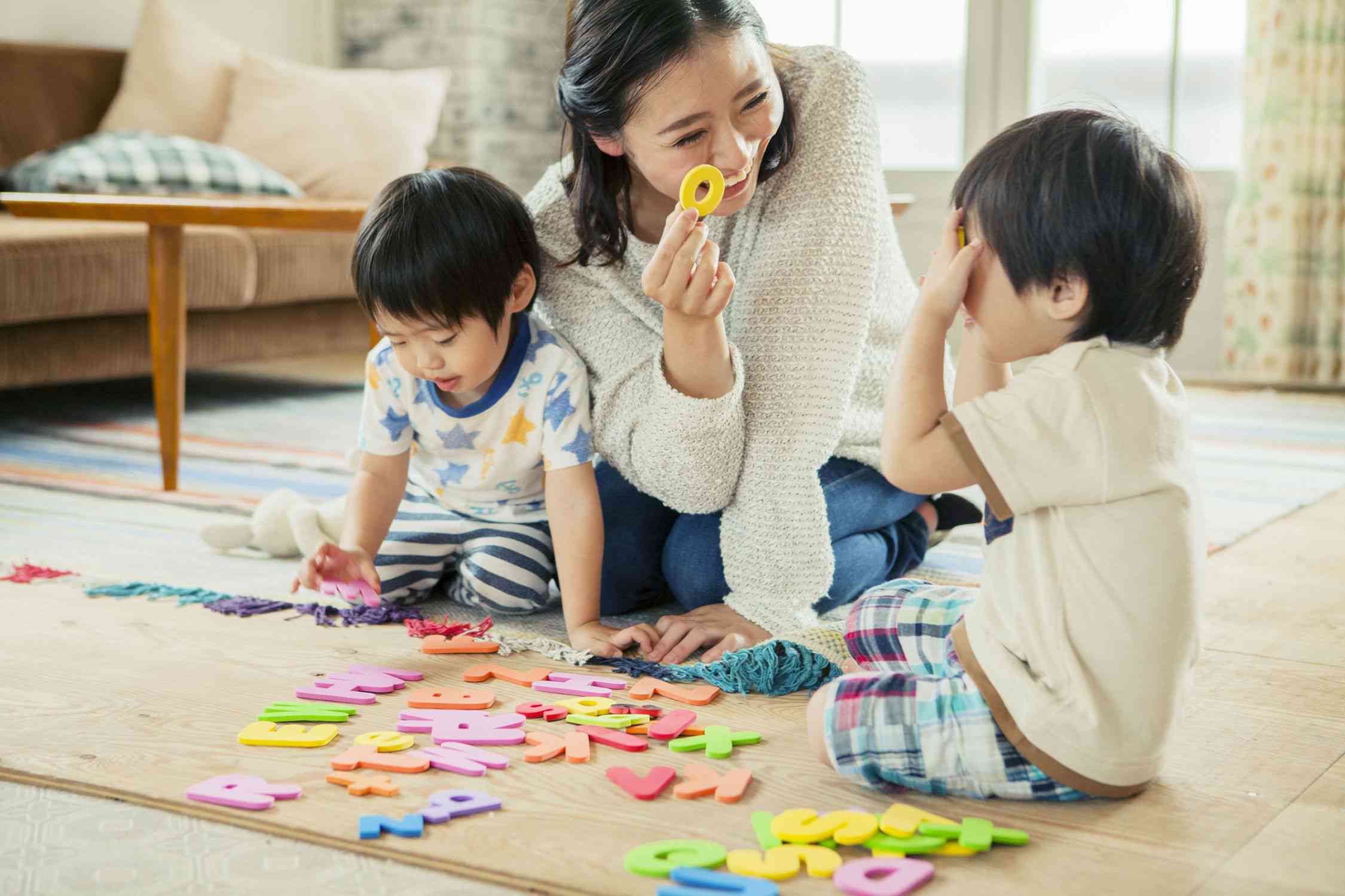 一个妈妈和她的孩子们玩字母的照片