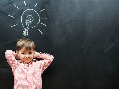 boy with lightbulb above his head on chalk board