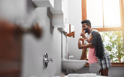 dad and daughter brushing teeth together