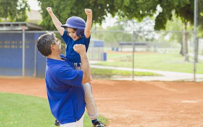 好的运动父母-父亲和儿子庆祝棒球比赛