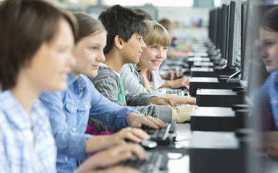 a row of children using computers