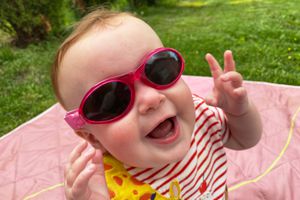 Baby wearing 100% UV protection sunglasses with a strap