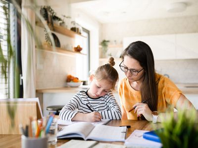 mom homeschooling young daughter