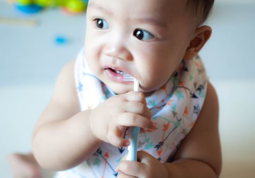 亚洲婴儿双手拿着牙刷