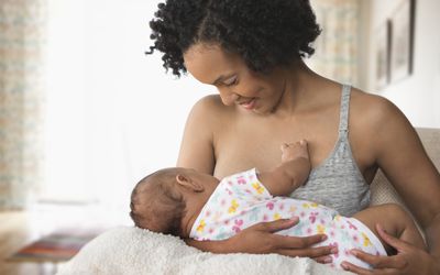 A parent breastfeeds her infant.