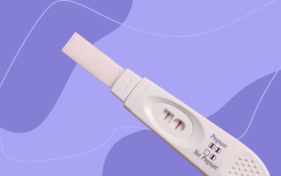 Stick pregnancy test displayed against a purple patterned background