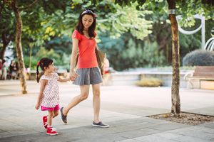 妈妈和蹒跚学步的孩子在公园里愉快地散步