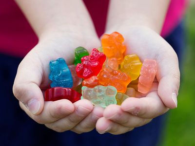 A child holding gummy candy.