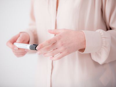 woman's hands holding black marker