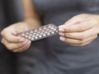 Woman holding blister pack of birth control pills