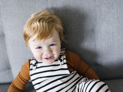 smiling baby boy in striped overalls