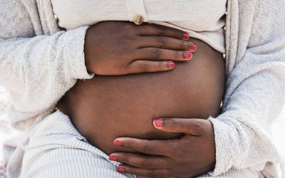 黑人妇女抱着怀孕的肚子