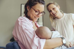 接生婆帮助正在哺乳的母亲和她的新生儿