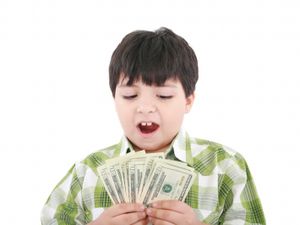 Boy with brown hair holds a stack of money and looks surprised