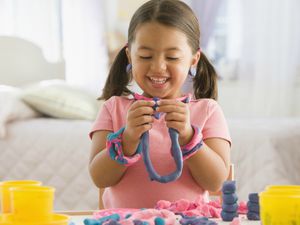 little girl playing with play dough