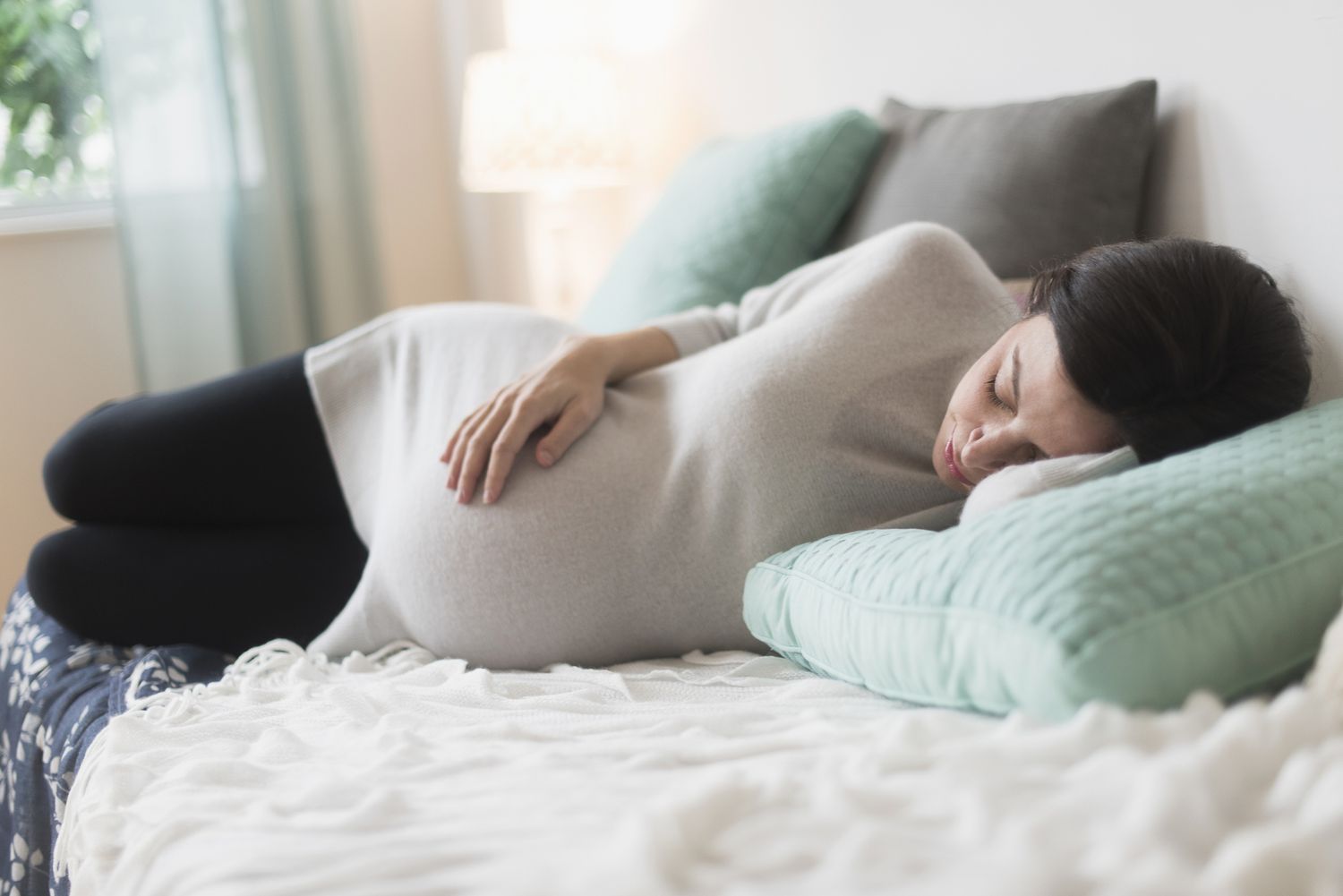 Pregnant woman sleeping in bed