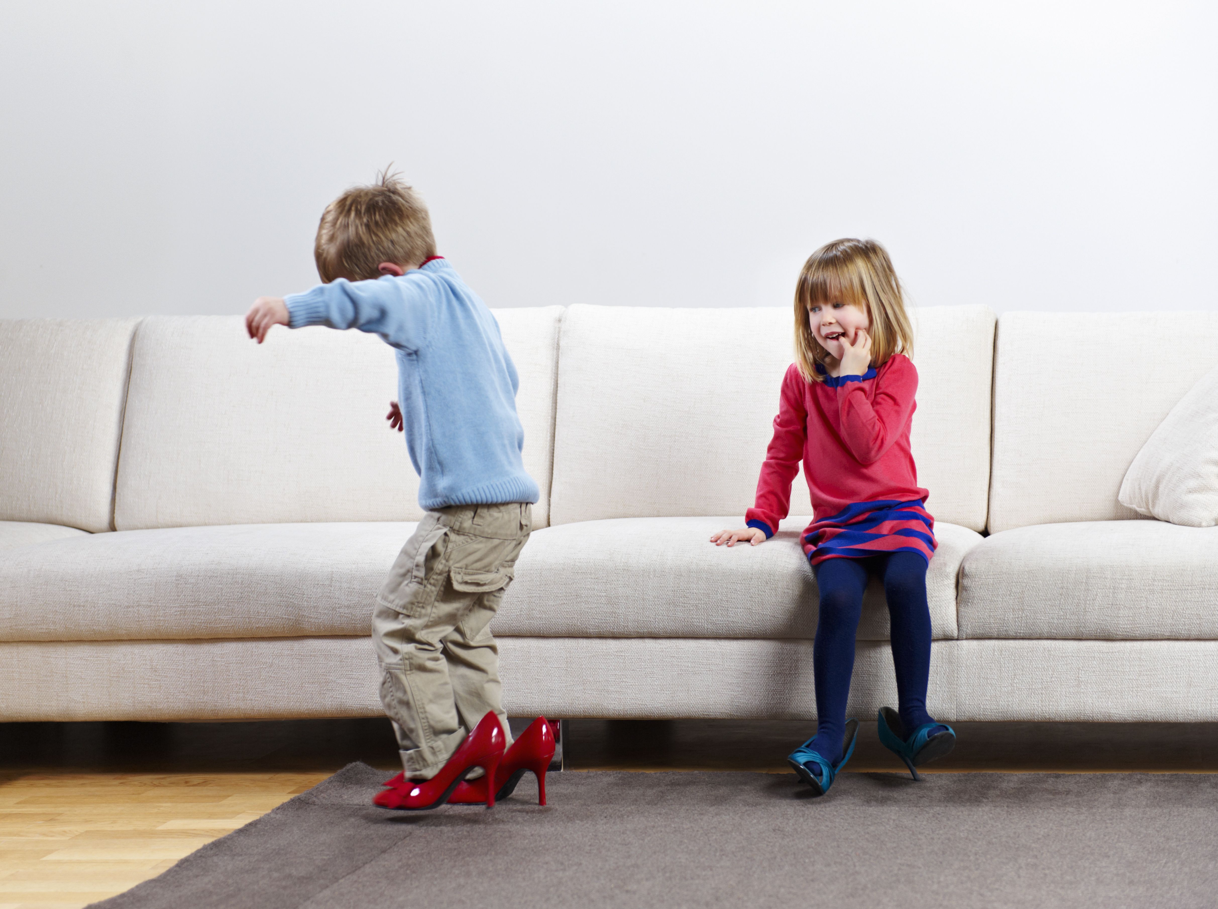 Young boy and girl walking in high-heels