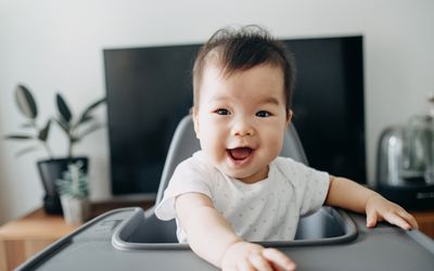 Asian baby in a high chair.