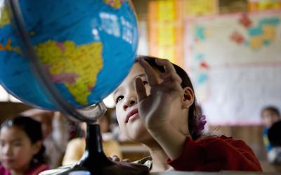 中国，广西，女孩(6-9岁)在课堂上看地球仪