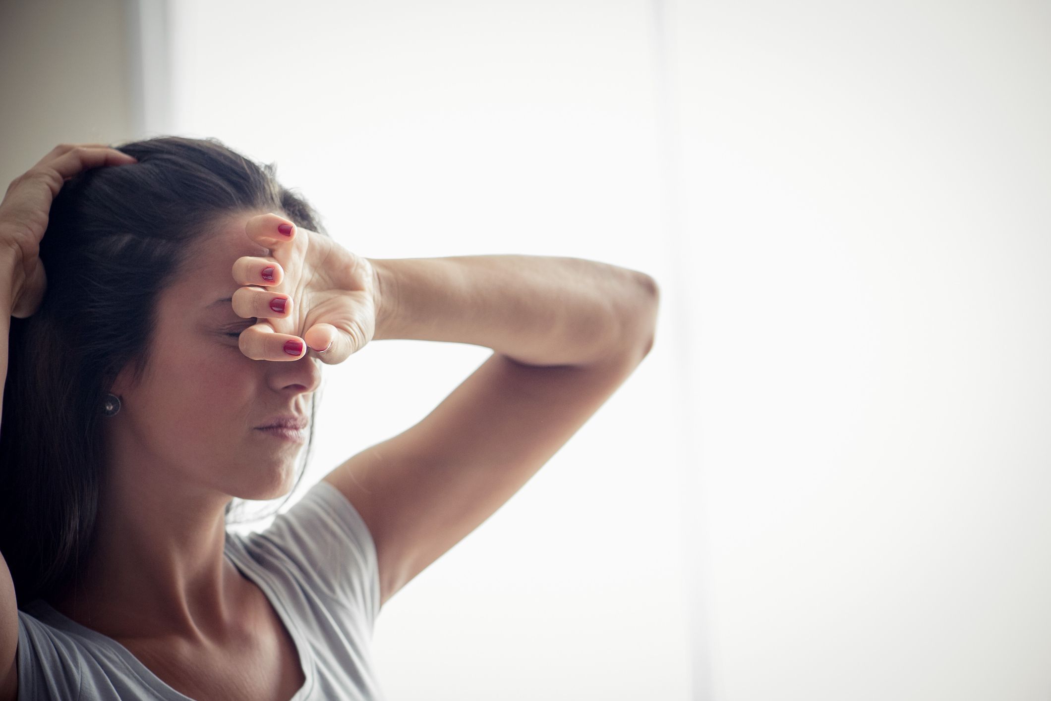 疼痛中的女人把她的手臂举到头上