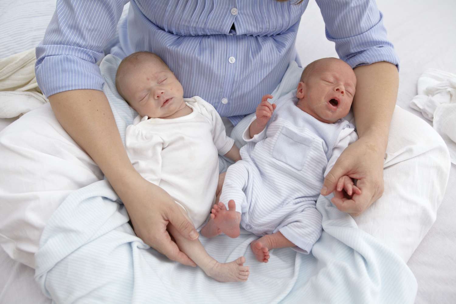 baby twins in mom's lap