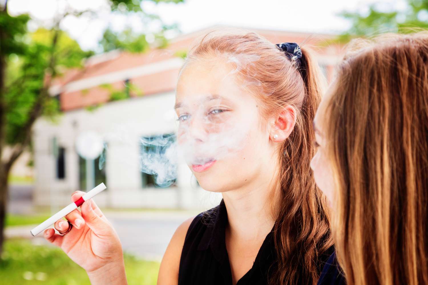 Young girl vaping with an e-cigarette