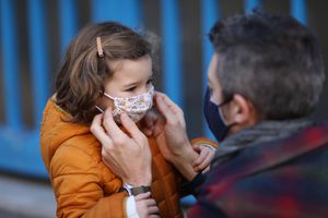 dad helping child put on their mask