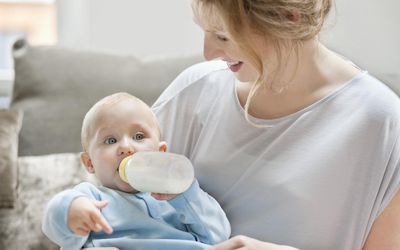 女婴用奶瓶吃奶。