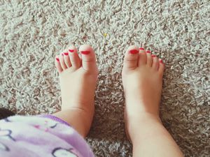 蹒跚学步的女孩涂了颜料的脚趾