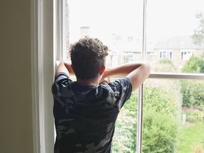 boy looking out of bedroom window