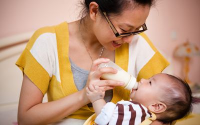 Mother feeding her baby with milk bottle