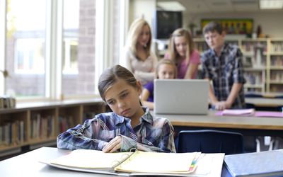 Teen sitting alone and being ignored