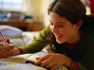 Teenage girl writing in a journal