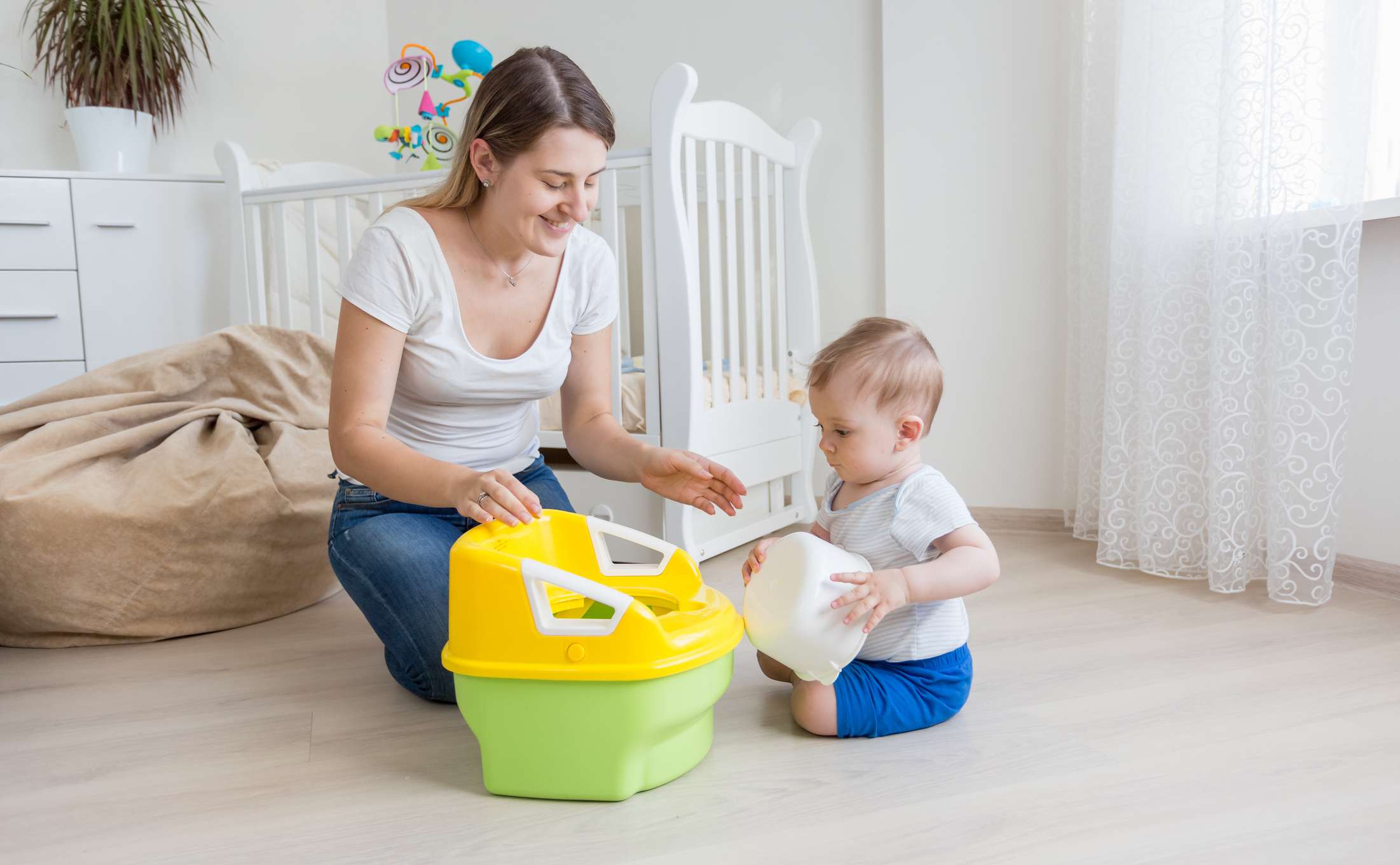 Mother teaching her baby boy how to use potty