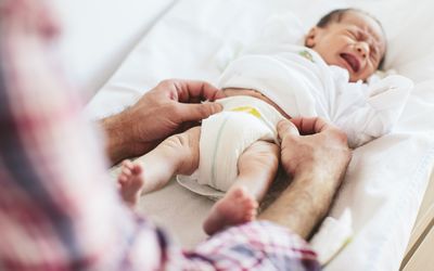 Parent changing newborn child's diaper