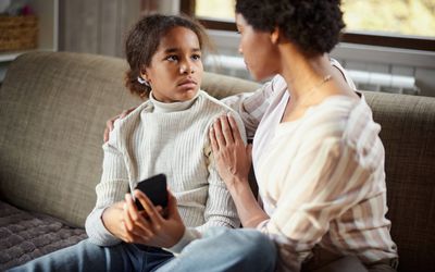 Sad girl talking to her mother at home